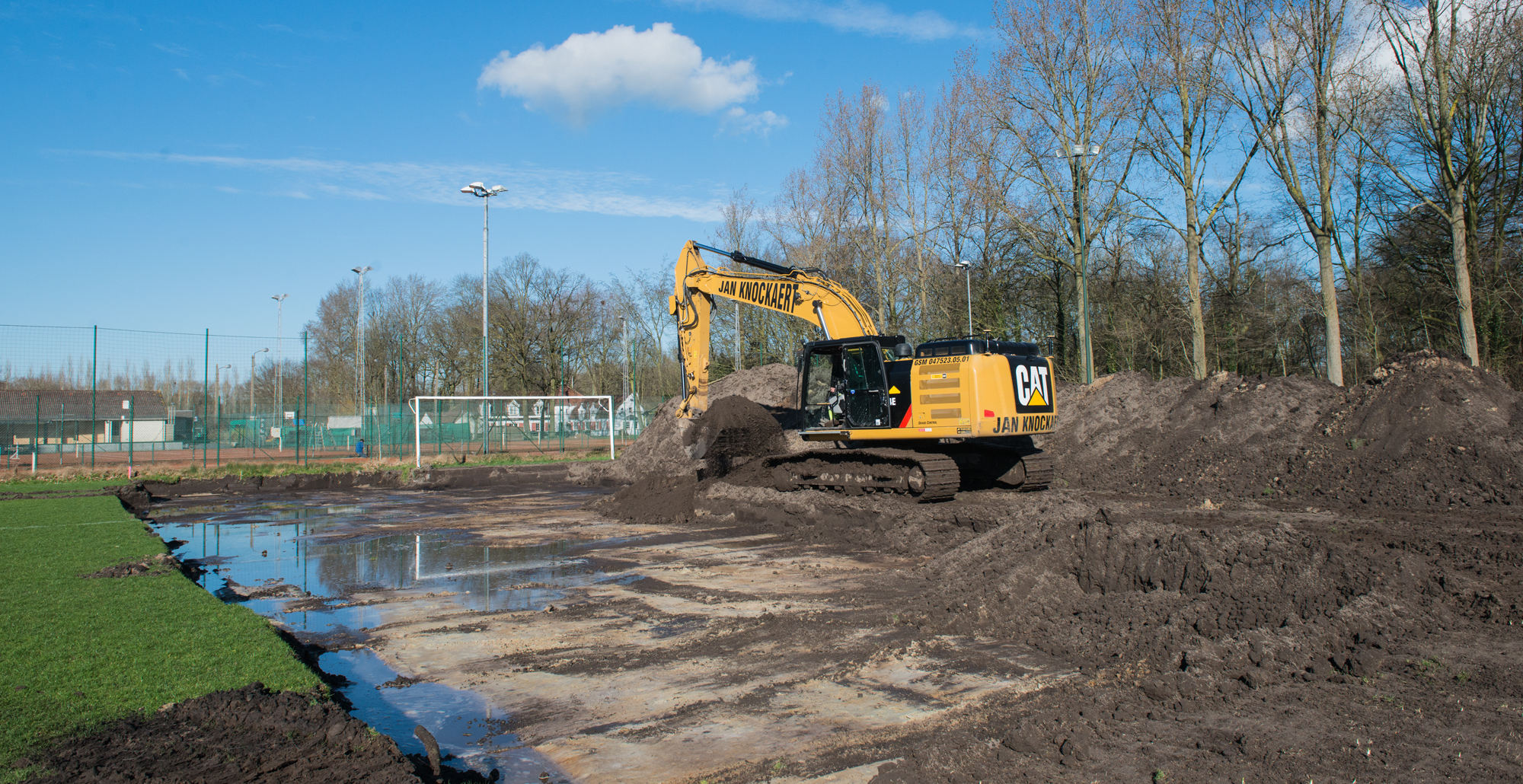 Uitgegraven bouwput naast een sportveld