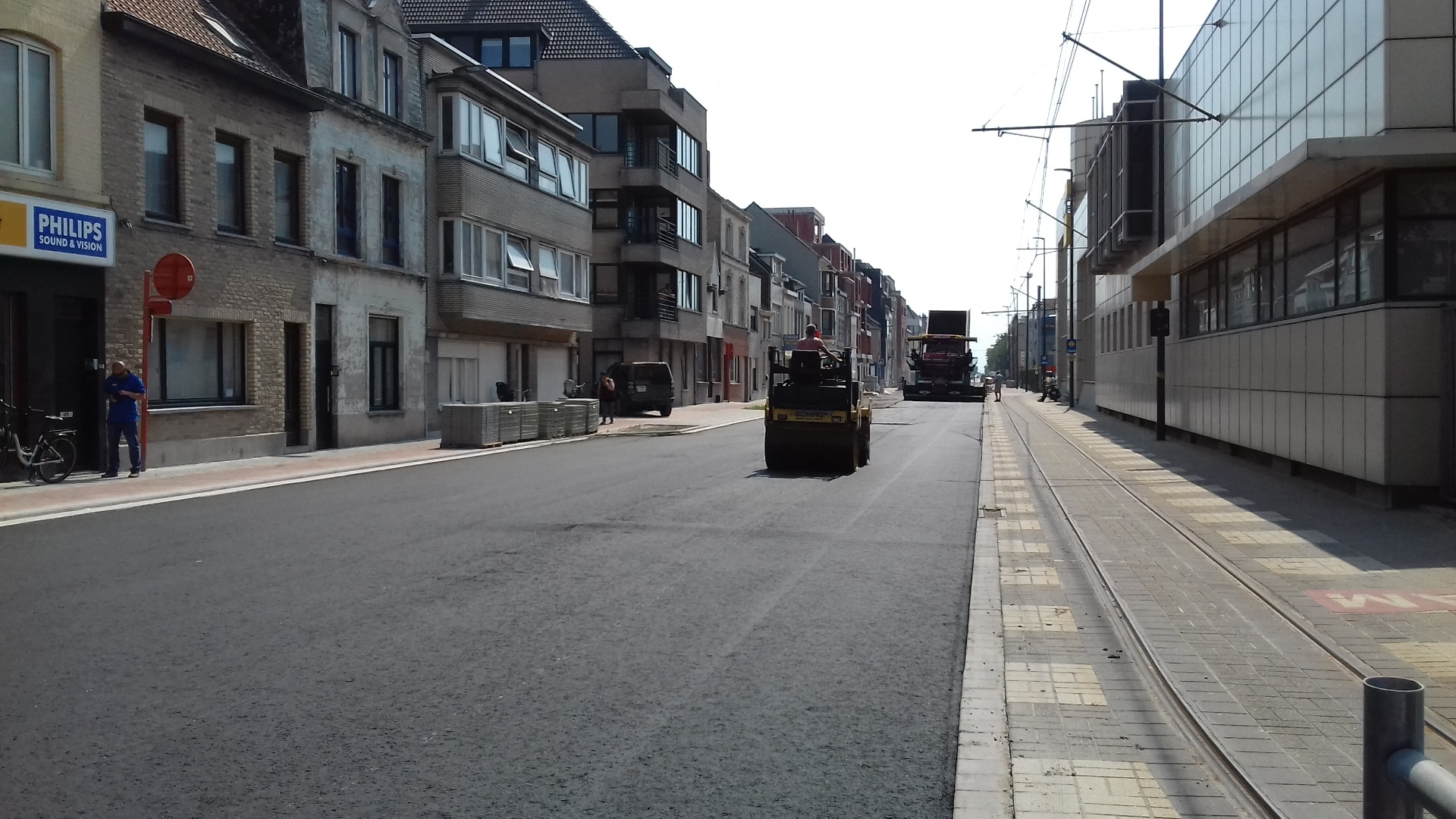 Nieuwe asfaltlaag in een stadsstraat met tramsporen